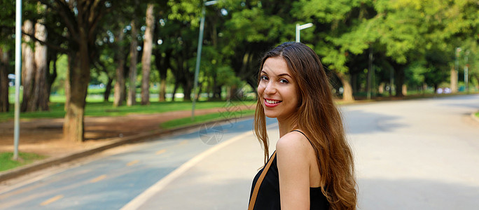 在圣保罗的伊比拉佩拉公园行走的美丽微笑的女人 全景横幅风景图片