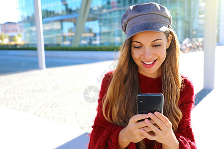 在现代城市使用智能手机的快乐美人儿 时尚秋冬少女肖像图片