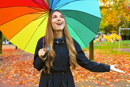 秋天的森林散步时 女人在雨中撑着伞很开心 女孩享受着多雨的秋天 抬头望着天空微笑着开朗图片