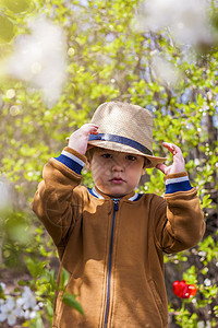 可爱的小男婴在花园里戴着帽子 一个迷人的小孩帮助他的父母种菜晴天园艺植物园丁喷壶男生家庭收成蔬菜靴子图片