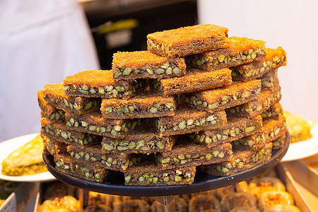 传统的土耳其甜点 kadayif 在糖浆中烘烤的切碎面团和碎坚果爱好者开心果火鸡奢华甜食烹饪小吃文化糖果食物背景图片
