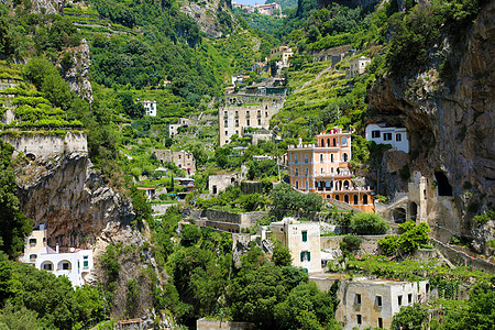 在意大利阿马尔菲海岸阿特拉尼村与葡萄园一起自然形成的岩石山上散乱的房屋图片