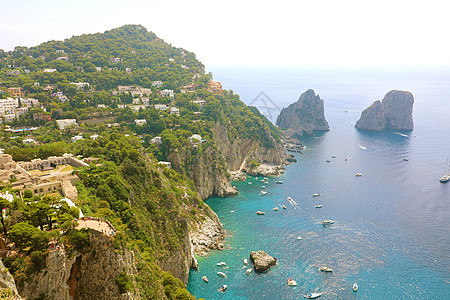 意大利卡普里岛的景色在美丽的夏日中 与法拉格里奥尼岩石石头旅行海岸天堂假期蓝色游艇晴天悬崖场景图片