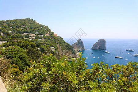 意大利卡普里岛的景色在美丽的夏日中 与法拉格里奥尼岩石海洋蓝色天空悬崖港口游艇海滩全景旅游天堂图片