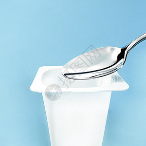 蓝底面的酸果杯和银勺 白色塑料容器 新鲜奶制品 用于健康饮食和营养食物小吃勺子杯子茶点酸奶乡村产品饮食奶油图片
