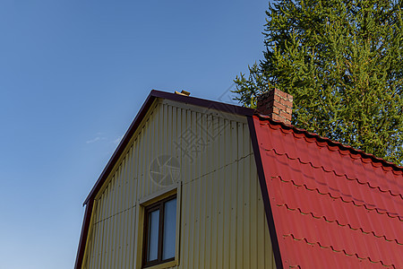 阁楼红色屋顶是用房子的金属和窗子制成的 白天在门外 后视图片