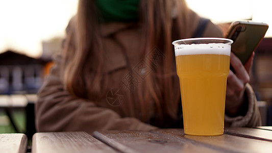 轻啤酒在一个塑料玻璃杯里 女孩在食品法院喝啤酒庆典成人派对喜悦干杯旅行潮人享受酒精朋友们图片