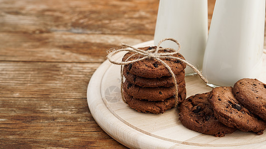 土制巧克力薯片曲奇和牛奶 在木木背景上以生锈风格丝带木板面包美食小吃饼干玻璃面包屑团体甜点图片