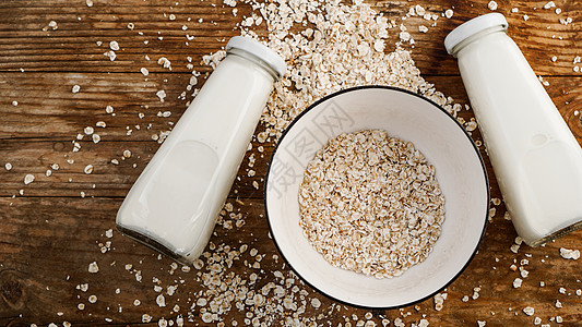 白碗中的Oat薄片和鲜奶瓶厨房国家瓶子麦片营养小麦食物木头种子盘子图片