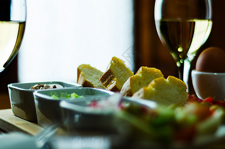 酒杯中的白葡萄酒 木制桌上有开胃菜 一套起首器 用一杯红酒放松精神白酒午餐器皿菜单高脚杯品尝者酒吧餐厅饮料图片