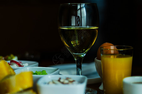酒杯中的白葡萄酒 木制桌上有开胃菜 一套起首器 用一杯红酒放松液体高脚杯小吃器皿享受午餐庆典用餐起动机溪流图片
