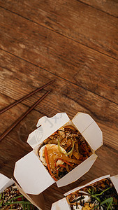 带猪肉和蔬菜的面条 装在木制桌上的外卖盒美食炒锅食物纸盒桌子纸板烹饪零售牛肉胡椒图片