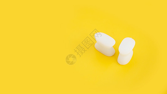 黄色背景上的白硅胶手指隔切器宽慰骨科脚趾女士身体药品失败老茧手指畸形图片