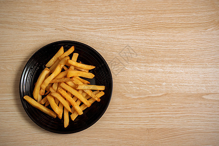 木制桌上黑板上的炸土豆薯条黄色盘子餐厅食物桌子乡村奶油黑色熏肉图片