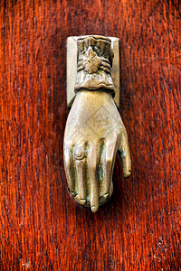 旧木制门上有手形状的金敲门机金属装饰品装饰门把手古董入口建筑学金子青铜宏观图片