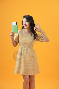 美丽的肖像 年轻的亚洲女性 微笑的手势OK 在黄色背景上 持有护照手指高清图片素材