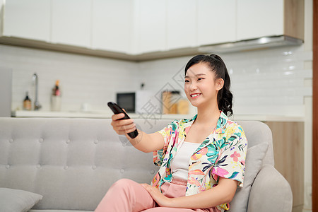 在家沙发上看电视的金发美女电视长椅女孩女性娱乐成人女士幸福房间控制图片