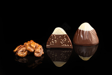 巧克力糖果在深色背景上 带反射 逐块和整块 充斥着坚果和水果可可薄荷大豆棉花花生包装纸甜蜜咖啡礼物活力图片