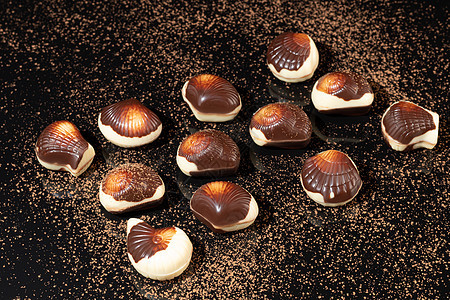 巧克力糖果在深色背景上 带反射 逐块和整块 充斥着坚果和水果棉花礼物大豆薄荷咖啡盒子花生食物甜点酒吧图片