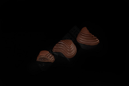巧克力糖果在深色背景上 带反射 逐块和整块 充斥着坚果和水果咖啡盒子李子花生可可礼物甜蜜食物包装纸活力图片