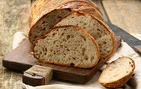 由木板上白小麦板制成的圆面包 面包切成碎片早餐面团营养食物小麦白色硬皮包子棕色面粉图片