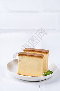 Castella kasutera  美丽美味的日本切片海绵蛋糕食品在质朴的白色木桌上的白盘上 特写 复制空间设计理念乡村薄荷咖图片