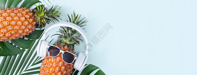 穿着白色耳机的有趣的菠萝 听音乐的概念 与热带棕榈叶隔绝在彩色背景上 高视线 平板设计水果平铺海滩高架食物凤梨太阳镜乐趣眼镜音乐图片