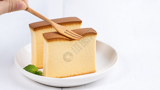 Castella kasutera  美丽美味的日本切片海绵蛋糕食品在质朴的白色木桌上的白盘上 特写 复制空间设计理念杯子薄荷桌图片