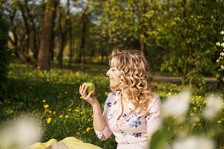 在夏日花园野餐上吃苹果的女人收成农村毯子正方形享受食物幸福金发女郎水果女士图片