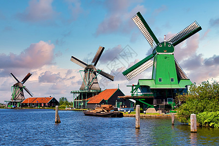 荷兰风车停在靠近荷兰阿姆斯特丹的绿色农村 有蓝天和河流水桑色蓝色旅游场地活力旅行村庄天空房子文化图片