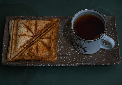 茶海早餐三明治和一杯茶 在陶瓷沙发上杯子背景