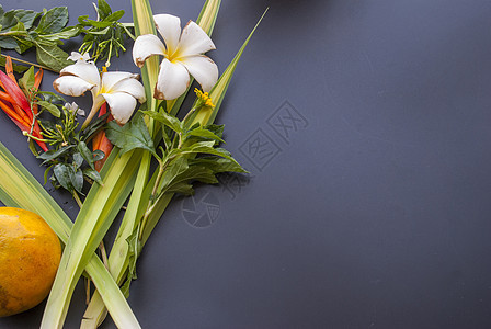 黑桌上安排的花朵种类繁多橙子黑色黄花红色绿色背景图片