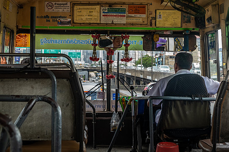 在Bangkok路上的一辆旧巴士上的公共汽车司机道路眼镜男人运输车轮交通工作图片