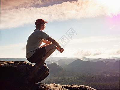 人类在山顶上坐着 享受冒险吧 全景观图片