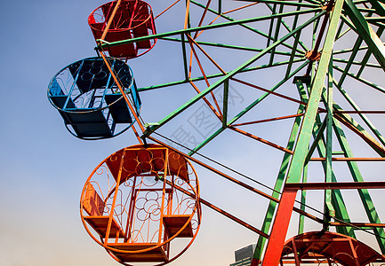 钢篮和轮轮式板红色旋转游乐场圆形桁架天空车轮橙子摩天轮绿色背景图片