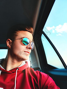 一名年轻人坐在一辆出租车的后座上 乘出租车去机场自拍自拍互联网奢华乘客人士男人电话太阳镜成年人技术座位图片