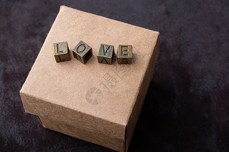 纸板盒上用金属字母表示的爱这个词盒子火花刻字情怀拼写学校创造力婚礼字幕背景图片