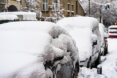 汽车上覆盖着今年第一场雪的积雪 冬天的概念 停在街上的雪车 厚厚的雪车辆暴风雪季节冻结城市气候交通层雪运输降雪图片