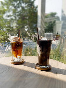 一杯冰的摩卡和冰的美式巧克力加椰子汁食物早餐咖啡杯桌子液体椰子汁木头玻璃杯子水果图片