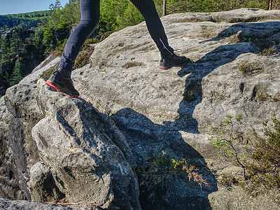 健壮人追逐跑向岩石山顶的奔跑者图片