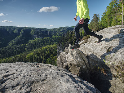 在山上漫步的足迹中跳跃时赛跑者慢跑者男人踪迹运动员日出冒险砂岩活动耐力图片