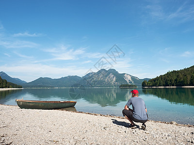 穿蓝衬衫的成年男子在山湖老渔船船上远足者酒店男人高山海岸线寂寞孤独森林调子远足图片