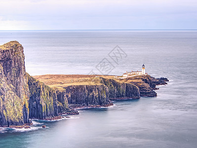 有灯塔的中点半岛 泡沫蓝色海面撞击尖悬崖 直冲悬崖图片