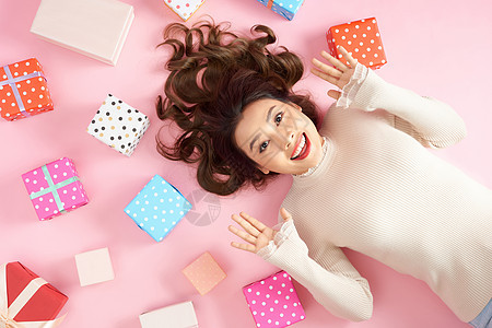 年轻亚洲兴奋的女人躺在粉红色的地板上 带着许多多彩的礼物盒女士女性粉色礼物女孩盒子庆典白色展示成人图片