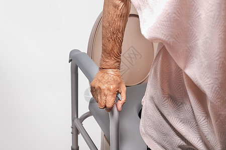 使用流动马桶座椅的老年妇女皱纹残疾人洗手间女性厕所栏杆人员老化卫生间女士图片