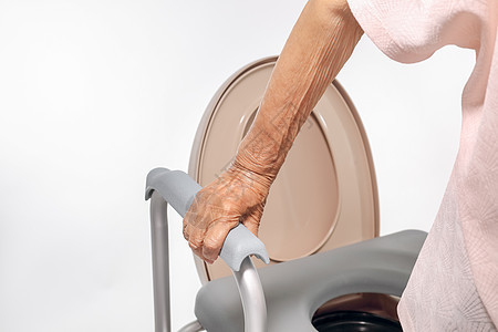 使用流动马桶座椅的老年妇女人员女性机动性残疾人厕所皱纹洗手间医院老化酒吧图片