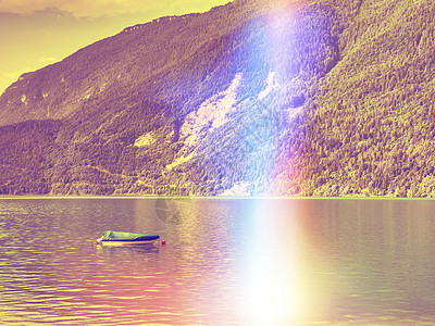 阿尔卑斯湖清晨平静 有锚定渔船图片
