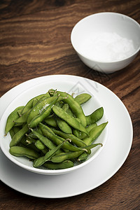 碗里吃豆子 桌上有海盐豆荚毛豆盐渍蔬菜食物小吃桌子绿色木头黄豆图片