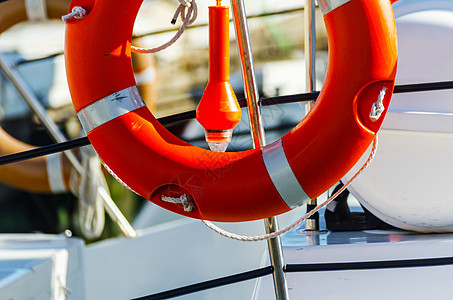 船上的橙色救生艇 海上拯救生命的基本工具之一救生员储蓄者甲板海滩救援警卫情况绳索浮标戒指图片