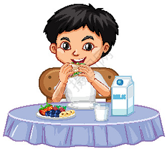 一个快乐的男孩在桌子上吃东西图片